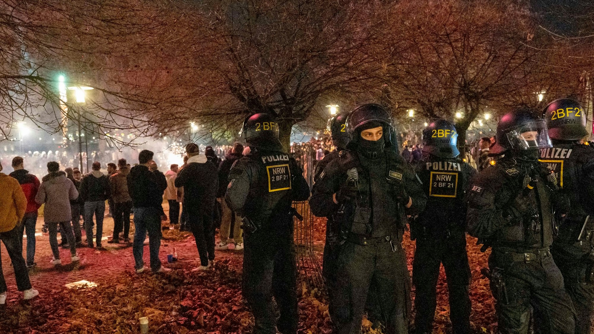 Polizisten stehen in der Nähe von Feiernden.
