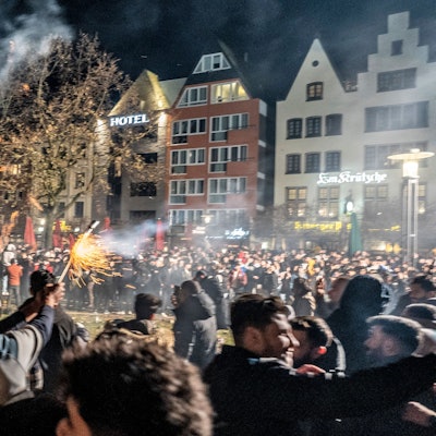 Dichtes Gedränge an der Frankenwerft, ein Mann zündet eine Silvesterrakete