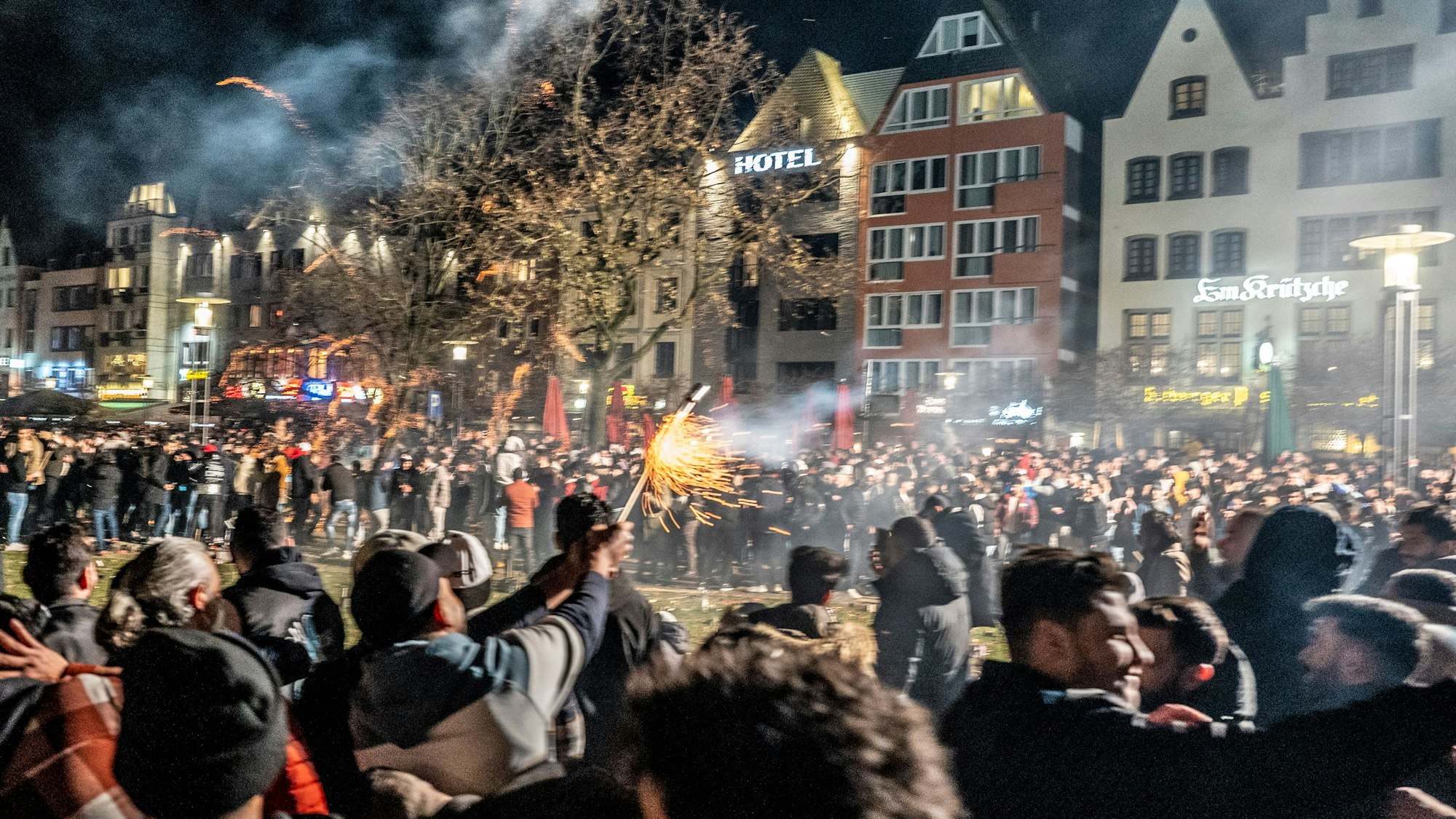 Dichtes Gedränge an der Frankenwerft, ein Mann zündet eine Silvesterrakete