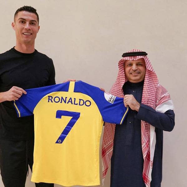 A handout picture released by Saudi Arabia's Al Nassr football club on their Twitter account shows Portugal's forward Cristiano Ronaldo being presented with the club's number seven jersey by club president Musalli Al-Muammar in Madrid on December 30, 2022 upon signing for the Saudi Arabian club. - Ronaldo signed for Al Nassr of Saudi Arabia, the club announced, in a deal believed to be worth more than 200 million euros. The 37-year-old penned a contract which will take him to June 2025. (Photo by Al Nassr Football Club / AFP) / == RESTRICTED TO EDITORIAL USE - MANDATORY CREDIT "AFP PHOTO / HO /AL NASSR FOOTBALL CLUB" - NO MARKETING NO ADVERTISING CAMPAIGNS - DISTRIBUTED AS A SERVICE TO CLIENTS ==
