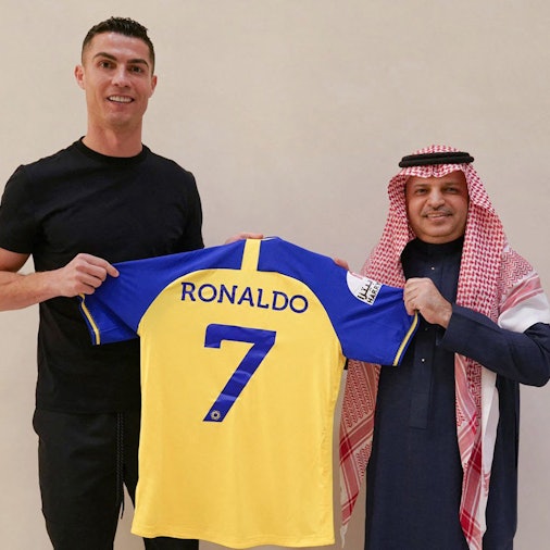 A handout picture released by Saudi Arabia's Al Nassr football club on their Twitter account shows Portugal's forward Cristiano Ronaldo being presented with the club's number seven jersey by club president Musalli Al-Muammar in Madrid on December 30, 2022 upon signing for the Saudi Arabian club. - Ronaldo signed for Al Nassr of Saudi Arabia, the club announced, in a deal believed to be worth more than 200 million euros. The 37-year-old penned a contract which will take him to June 2025. (Photo by Al Nassr Football Club / AFP) / == RESTRICTED TO EDITORIAL USE - MANDATORY CREDIT "AFP PHOTO / HO /AL NASSR FOOTBALL CLUB" - NO MARKETING NO ADVERTISING CAMPAIGNS - DISTRIBUTED AS A SERVICE TO CLIENTS ==