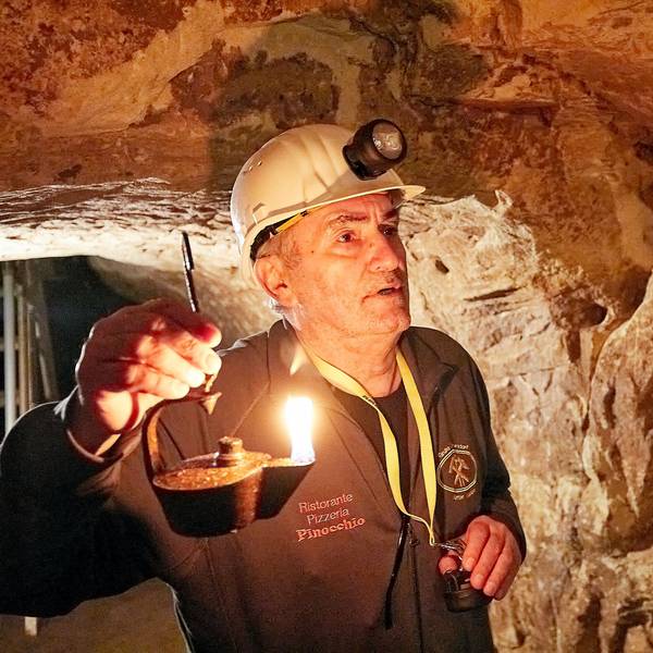 Ein Mann hält einen Grubenfrosch, die historische Öllampe der Bergleute.