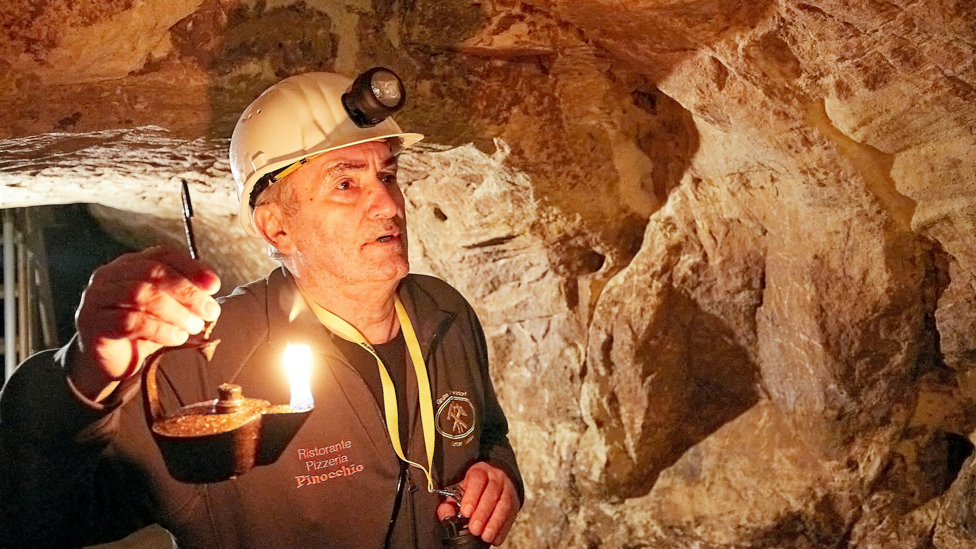 Ein Mann hält einen Grubenfrosch, die historische Öllampe der Bergleute.