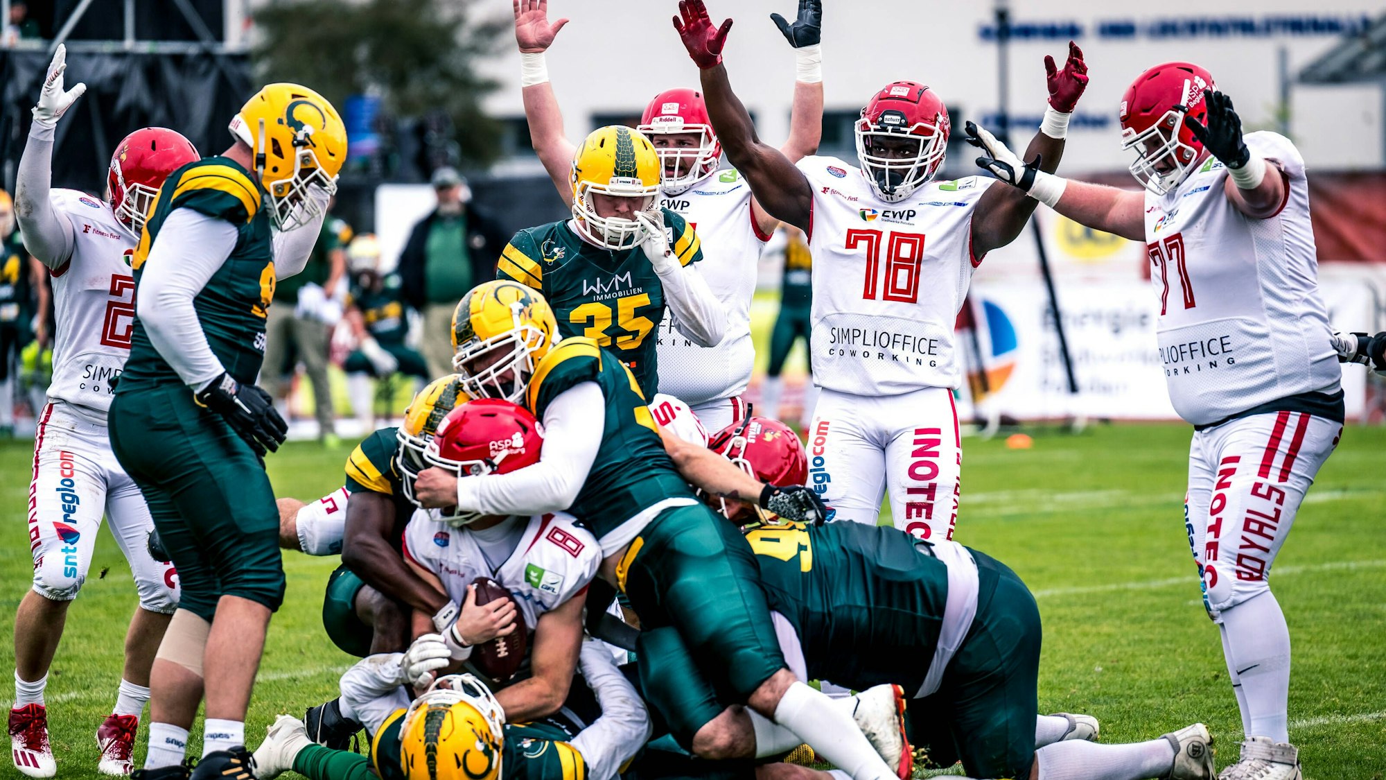 Mehrere Footballspieler liegen im Kampf um den Ball übereinander.