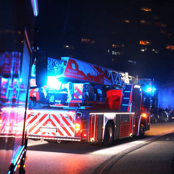 Ein Löschfahrzeug steht mit Blaulicht auf der Straße.
