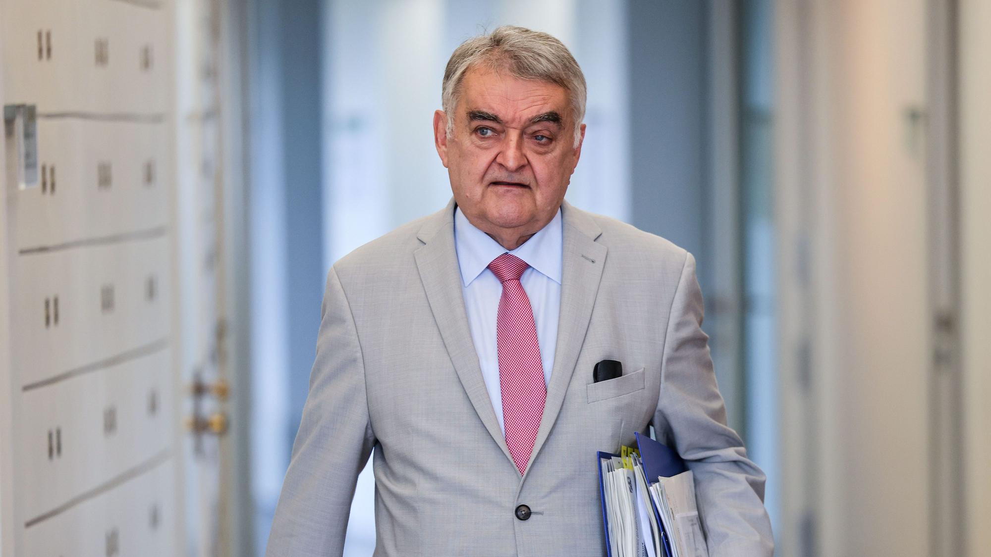 Innenminister Herbert Reul mit Akten unter den Arm geklemmt.