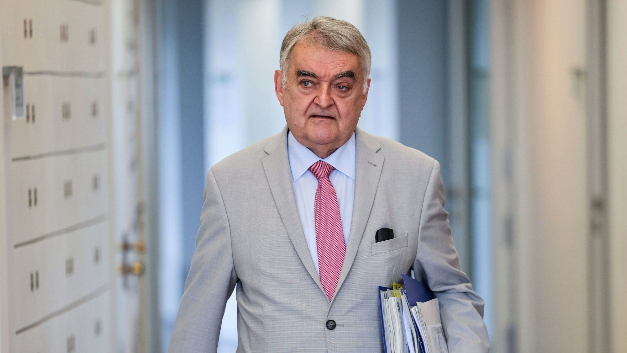 Innenminister Herbert Reul mit Akten unter den Arm geklemmt.