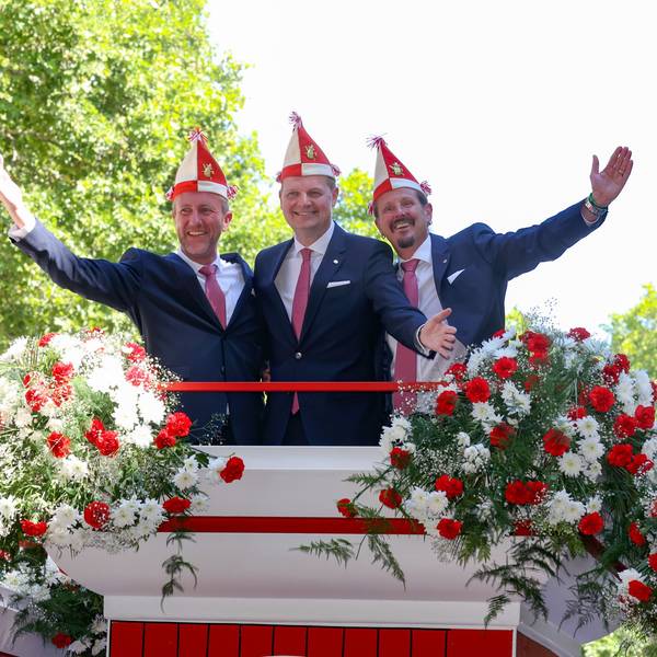 Bei der Vorstellung des designierten Kölner Dreigestirns 2023
sind André Fahnenbruck , Boris Müller und Marco Schneefeld zu sehen. Sie stehen einigen Blumen und halten die Arme in die Luft.