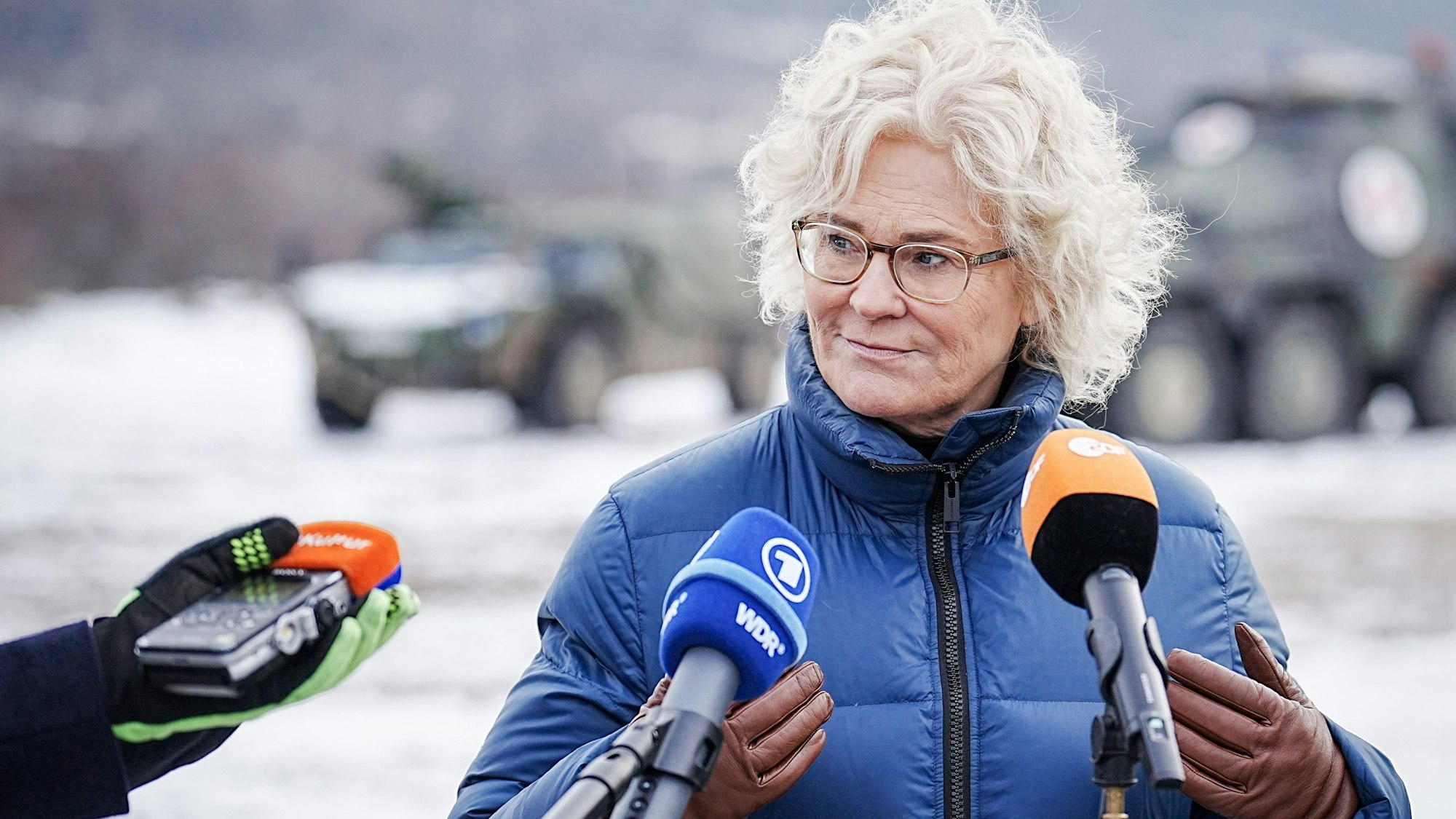 Bundesverteidigungsministerin Christine Lambrecht (SPD) steht in einer blauen Jacke vor Mikrofonen der Presse. (Archivbild)