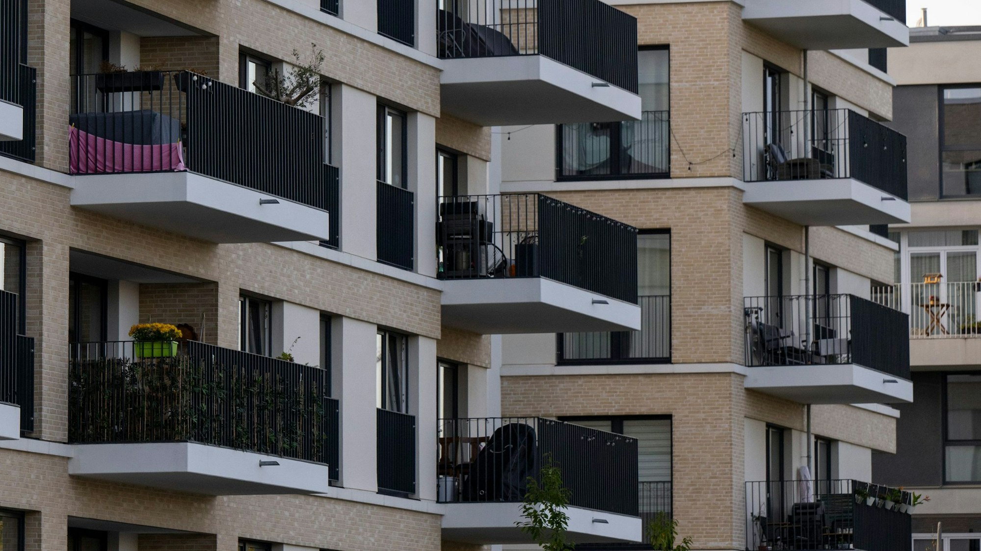 Zu sehen sind mehrere neu gebaute Wohnhäuser, deren Balkone dicht aneinander liegen.