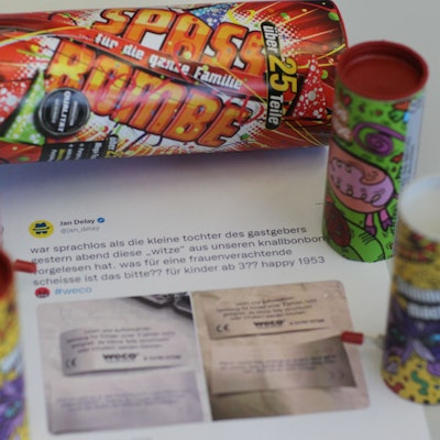 Der ausgedruckte Tweet von Jan Delay liegt auf einem Tisch, darum Knallbonbon-Verpackungen.