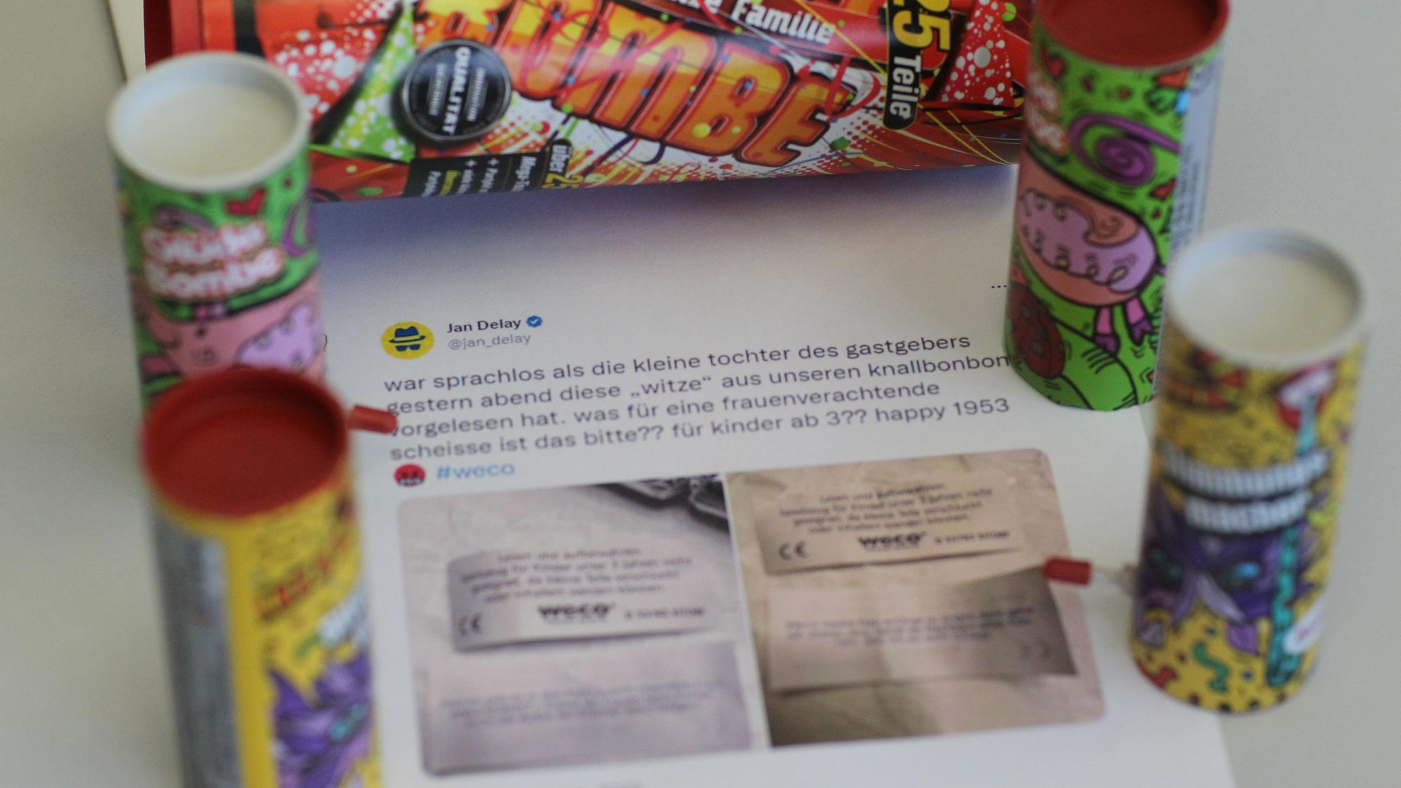 Der ausgedruckte Tweet von Jan Delay liegt auf einem Tisch, darum Knallbonbon-Verpackungen.