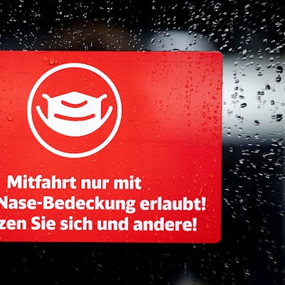 Ein Schild mit der Aufschrift „Mitfahrt nur mit Mund-Nase-Bedeckung erlaubt! Schützen Sie sich und andere!“ klebt an der Zugtür eines ICE der Deutschen Bahn
