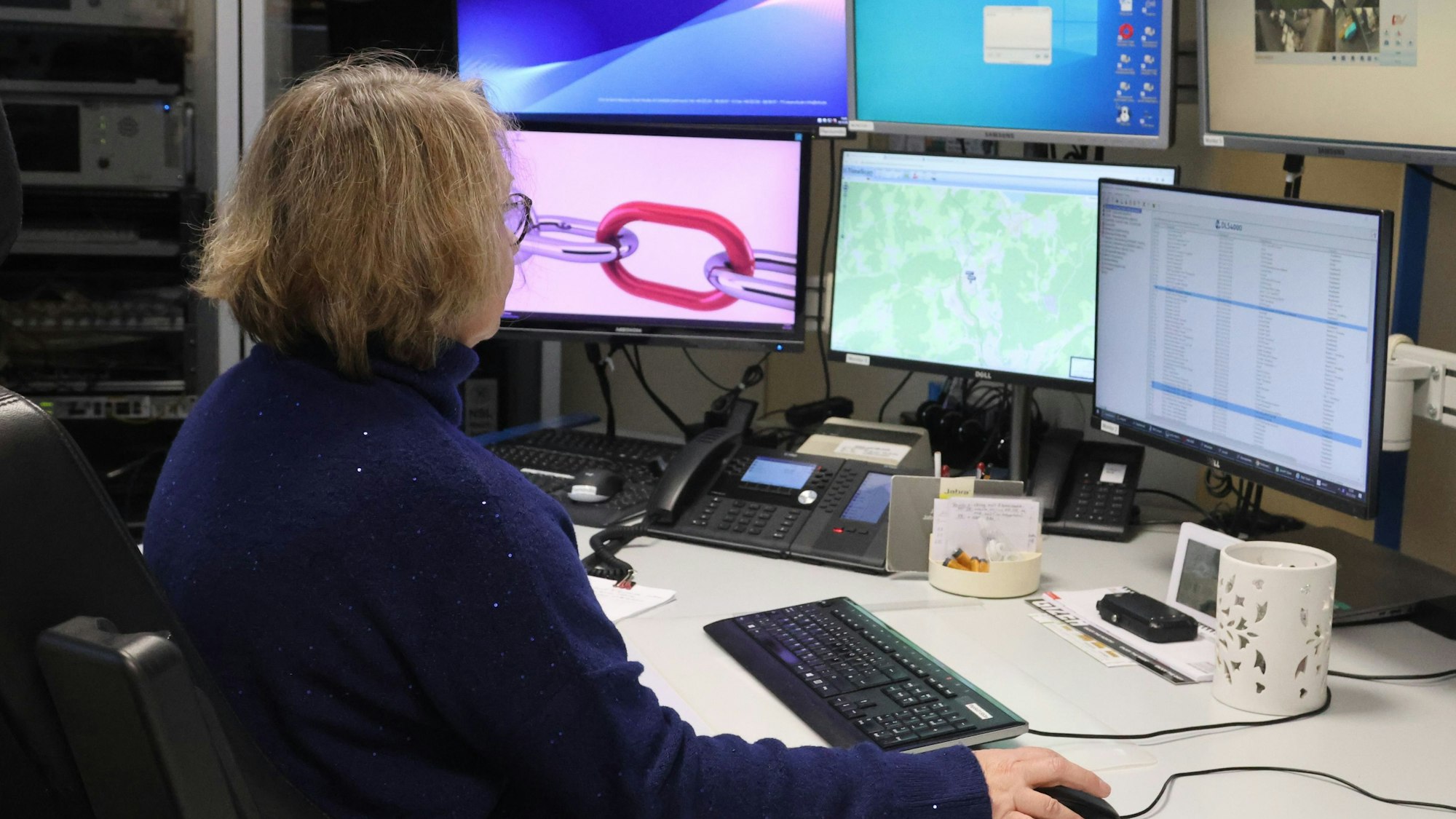 Claudia Waltereit in der Leitstelle vor zahlreichen Monitoren und technischem Gerät.