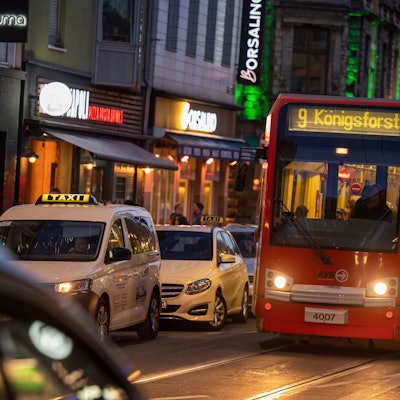 Eine Straßenbahn der Linie 9 fährt in der Dämmerung über die Zülpicher Straße.