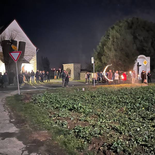 Menschenansammlung bei der Kapelle am Feld. Vereinzeltes Feuerwerk ist zu sehen.