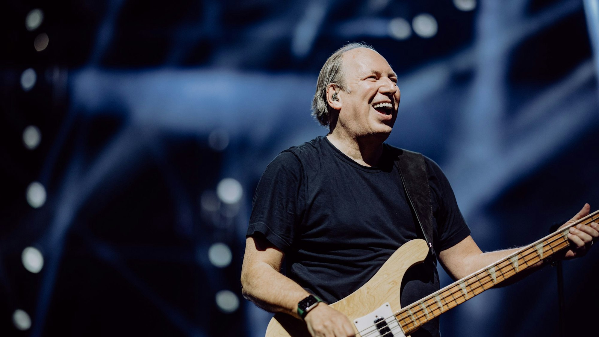 Hans Zimmer mit Gitarre auf der Bühne am lächeln.