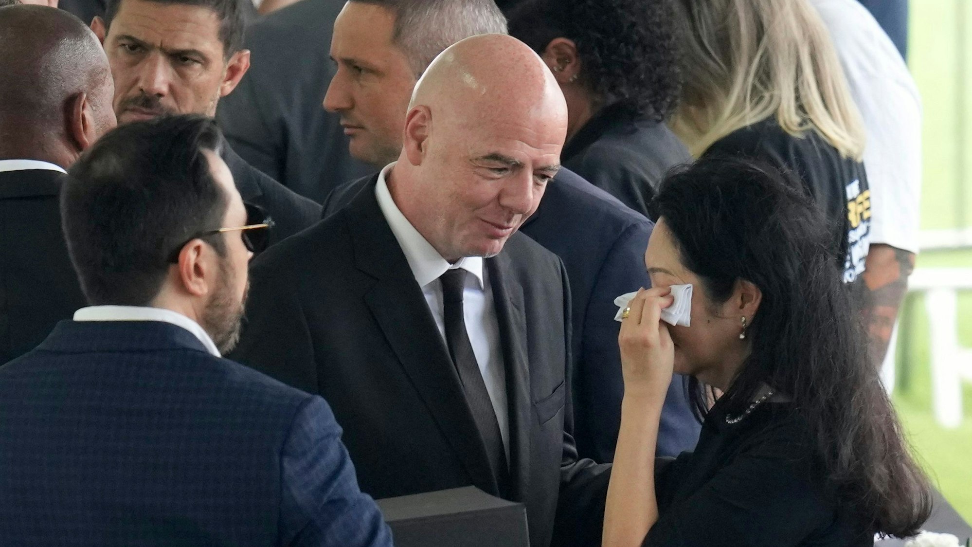 Gianni Infantino (M), Präsident der FIFA, spricht Marcia Aoki (r), Witwe des brasilianischen Fußballstars Pele, sein Beileid aus während der Totenwache im Stadion Vila Belmiro.