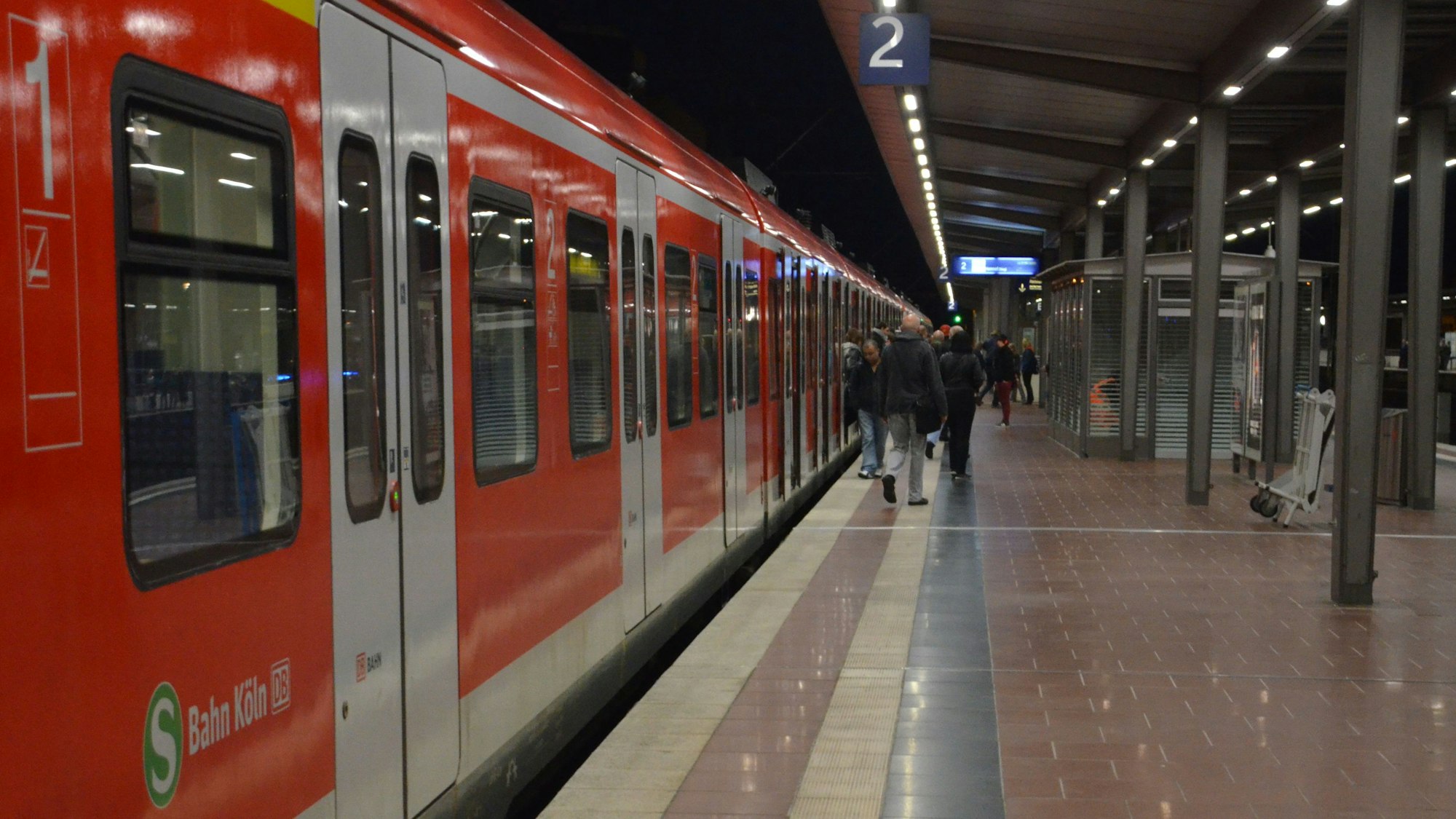 Menschen laufen über Gleis 2 im Bahnhof Siegburg zum Zug.