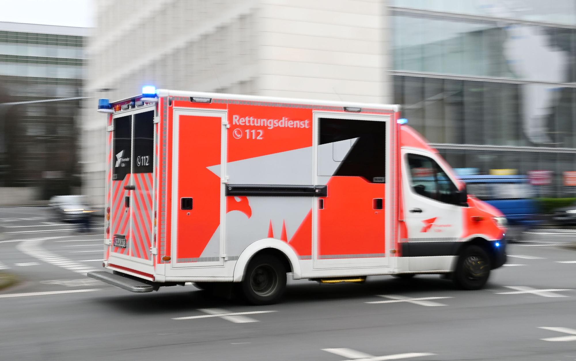 Ein Einsatzfahrzeug des Rettungsdiensts fährt mit Blaulicht über eine Kreuzung.