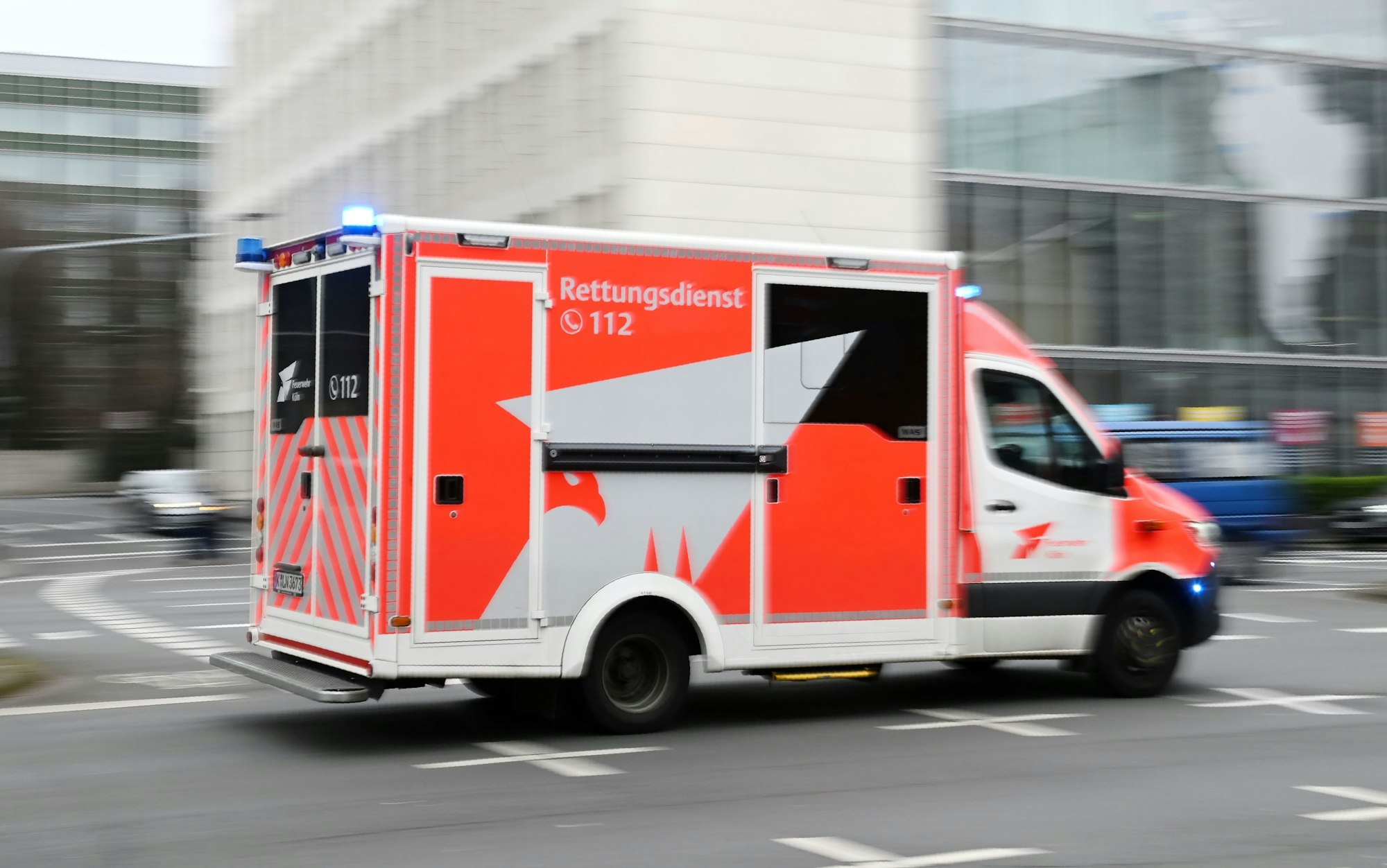 Ein Einsatzfahrzeug des Rettungsdiensts fährt mit Blaulicht über eine Kreuzung.