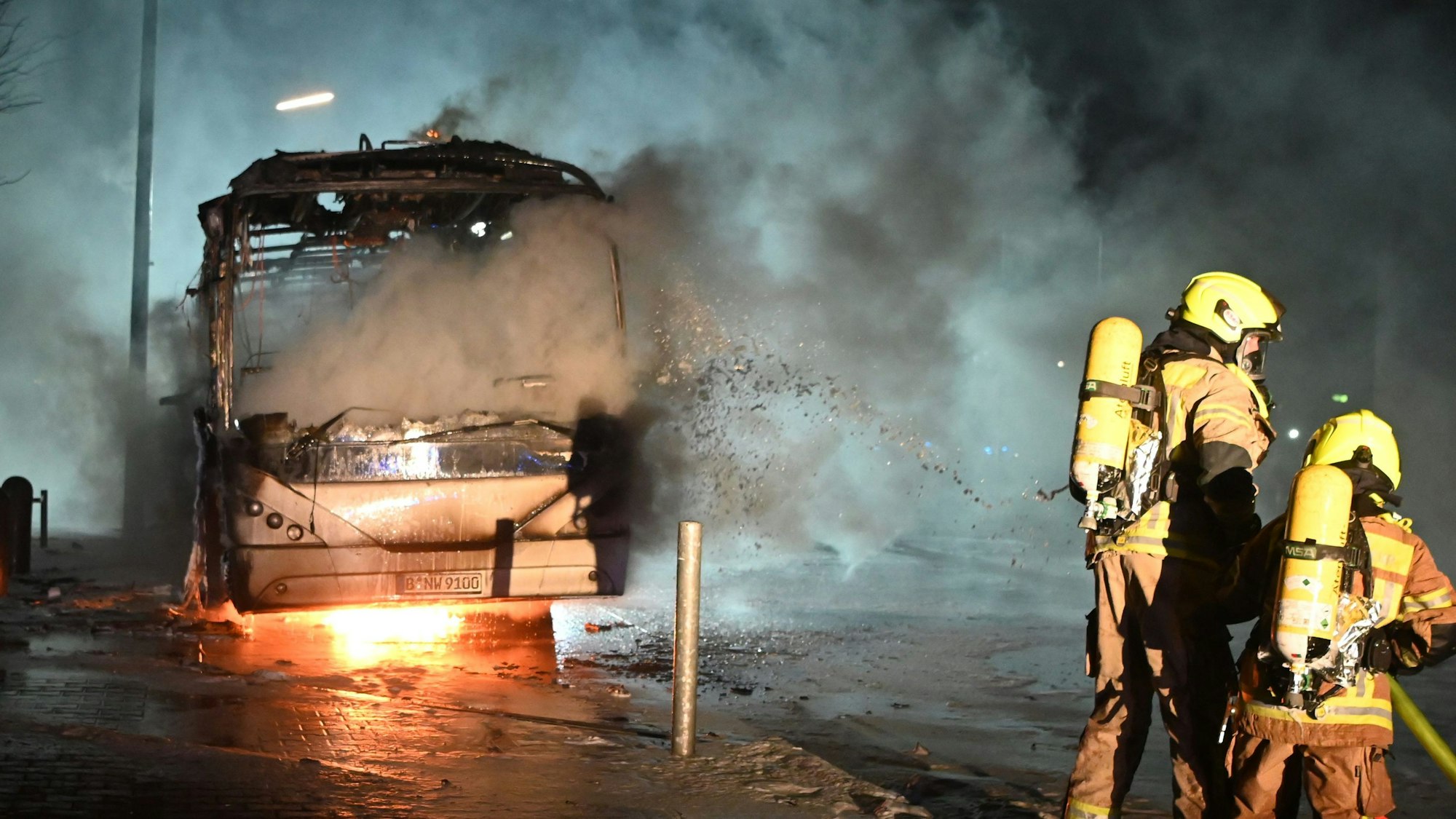 Berlin: Feuerwehrleute löschen an der Sonnenallee einen Reisebus, der von Unbekannten angezündet worden war.