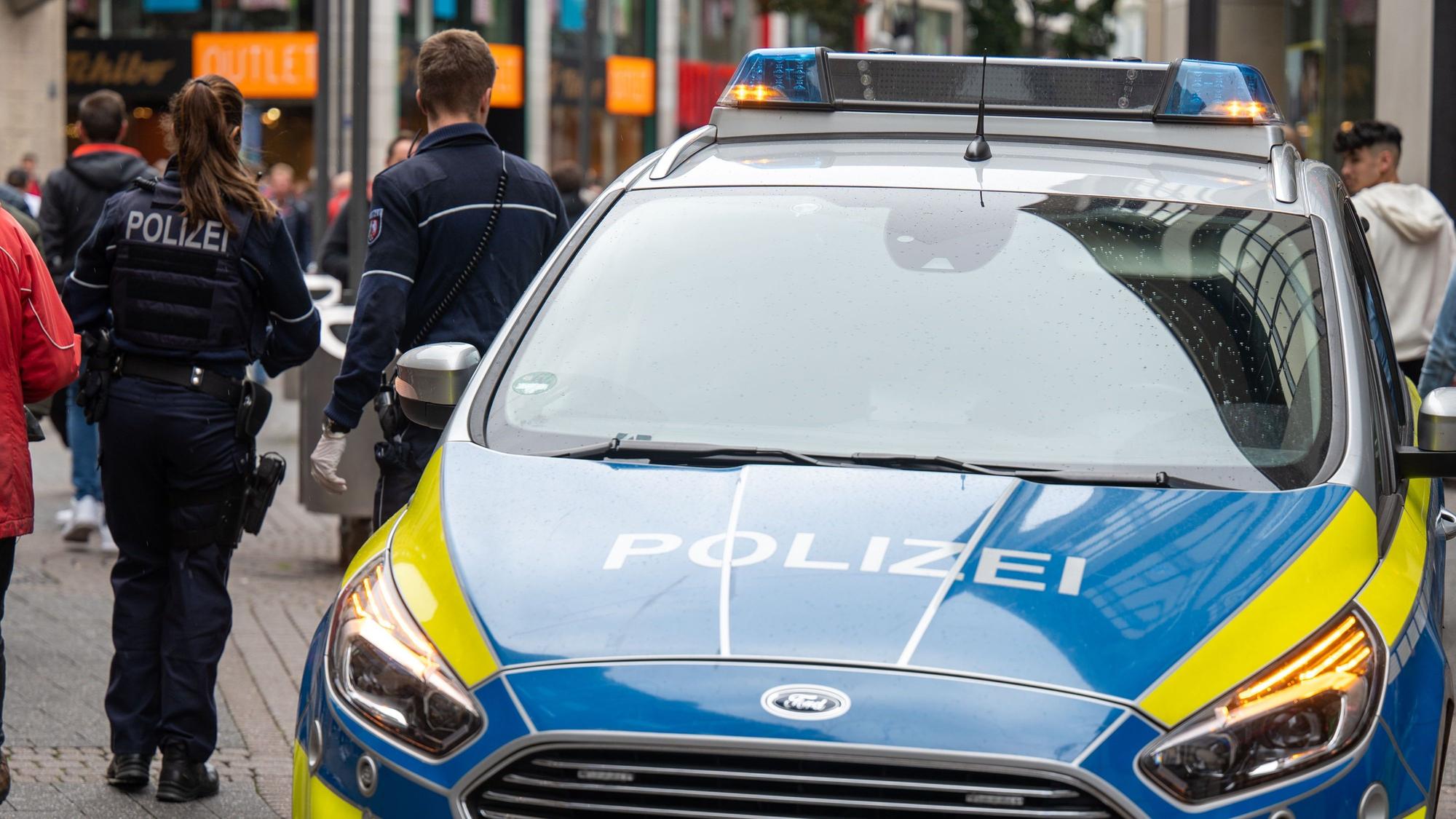 Polizeiwagen und zwei Beamte auf der Schildergasse.