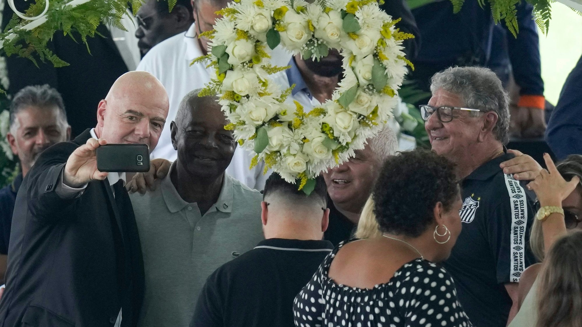 Fifa-Präsident Gianni Infantino (l) macht ein Selfie mit Lima, einem ehemaligen Spieler des FC Santos, und anderen während der Totenwache für den verstorbenen brasilianischen Fußballstar Pelé.
