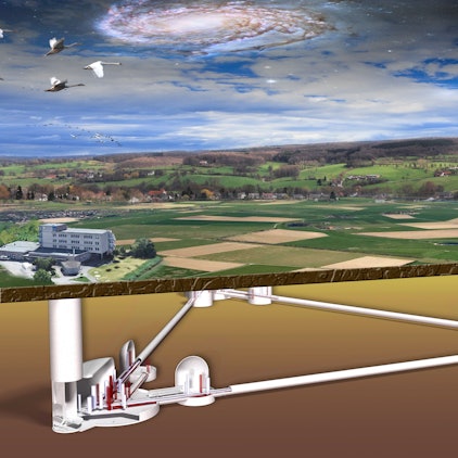 Das Bild ist eine Grafik, die den geplanten Bau des Einstein-Teleskops zeigt. Durch einen Querschnitt sieht man die Tunnel, die unterirdisch im Dreieck angeordnet sind. Oberirdisch ist die ländliche Region des Dreiländerecks sowie ein Institutsgebäude zu sehen.