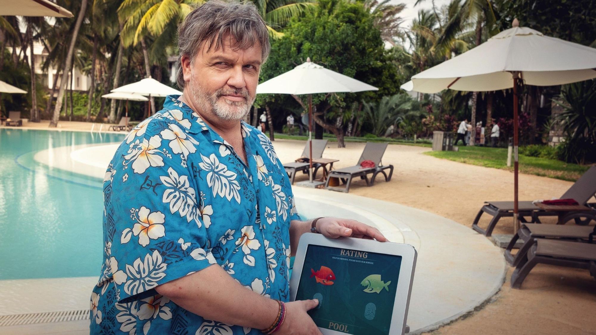 Hape Kerkeling steht in einem Hawaii-Hemd vor einem Pool. Er spielt Edwin Öttel in "Club Las Piranjas"