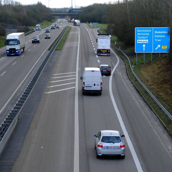 Auf einer Autobahn fahren mehrere Autos und Lkws.