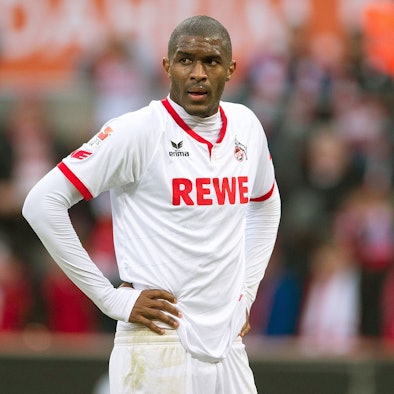 Fußballspieler Anthony Modeste steht im FC-Trikot auf dem Rasen und stützt die Hande in die Hüfte.
