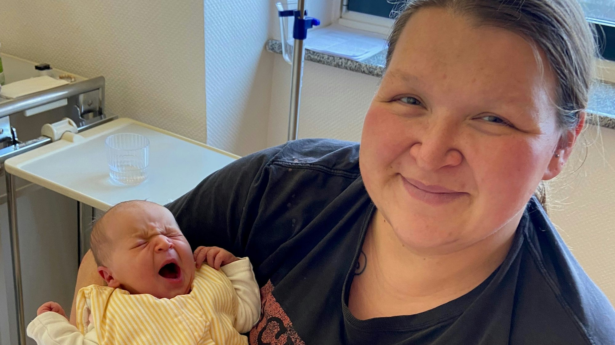 Mutter Corinna Cantzler hält ihr Neugeborenes in den Armen.