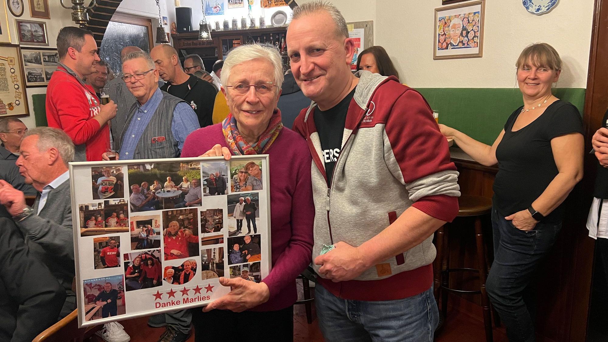 Michael Pütz vom FC-Fanclub Hemmersbach, hier im Januar 2023, überreicht eine Fotocollage an Marlies Wolter.