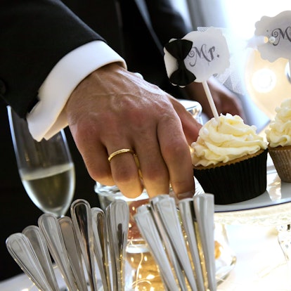 Ein Ehepaar hält zwei Muffins, auf denen steht „Mr. und Mrs.“.