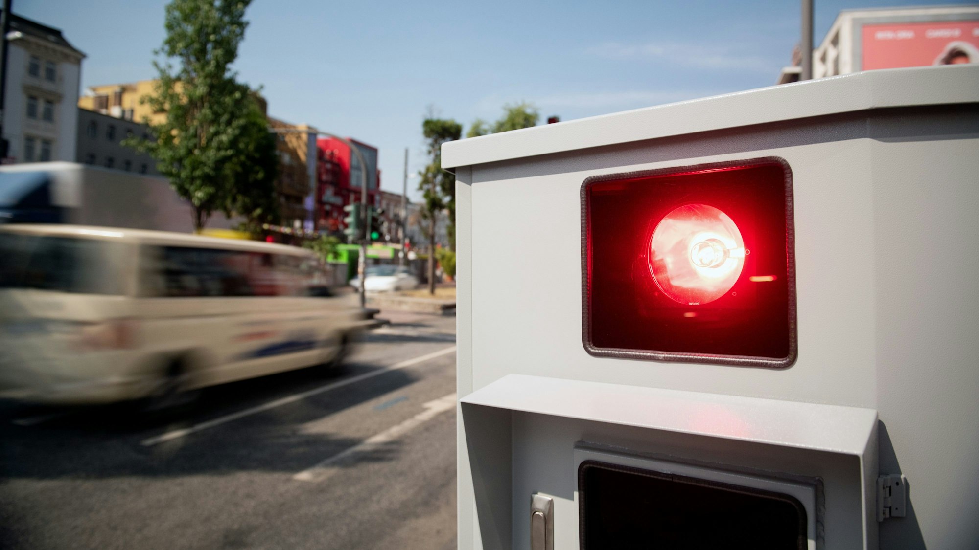 Ein Tempomessgerät steht an einer Straße und erfasst schnelle Autofahrer.