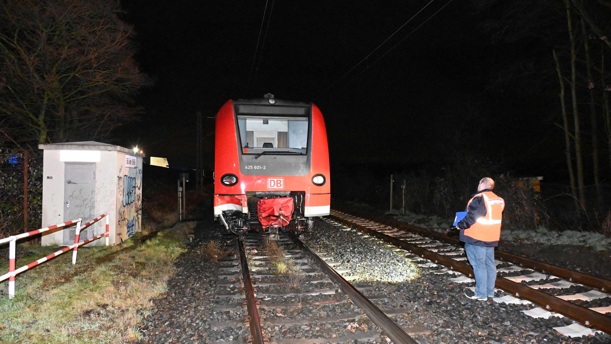 Ein Bahnmitarbeiter steht im Gleisbett, neben ihm steht der Zug, der zuvor die zwei Pferde überrollt hat.
