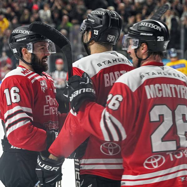 Spieler der Kölner Haie jubeln gemeinsam uaf dem Eis.
