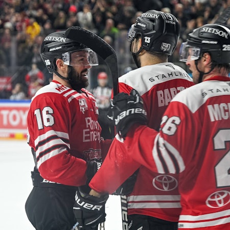 Spieler der Kölner Haie jubeln gemeinsam uaf dem Eis.