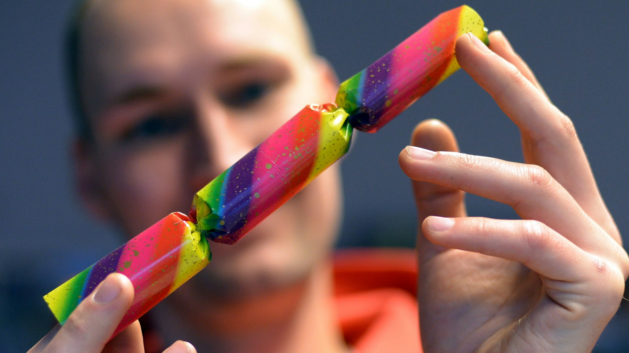 Ein Verkäufer sieht sich in einem Geschäft einen Knallbonbon an.