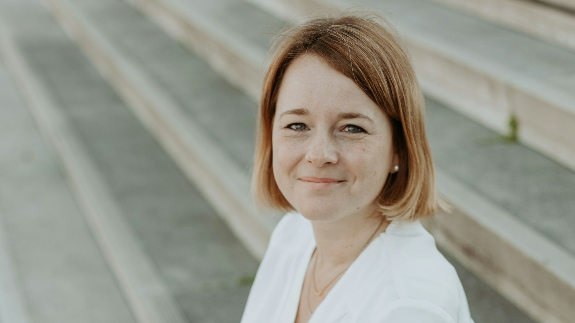 Hochzeitsplanerin Sabine Lippmann sitzt auf einer Treppe.