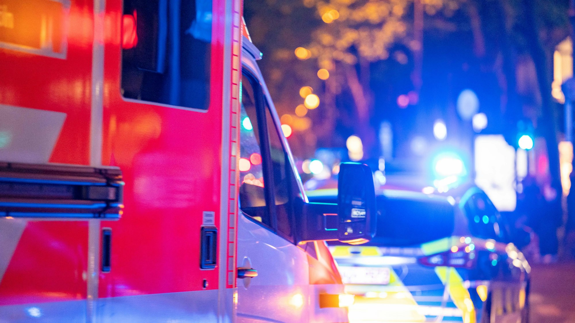Ein Polizeiwagen und ein Rettungswagen im Einsatz bei Nacht.