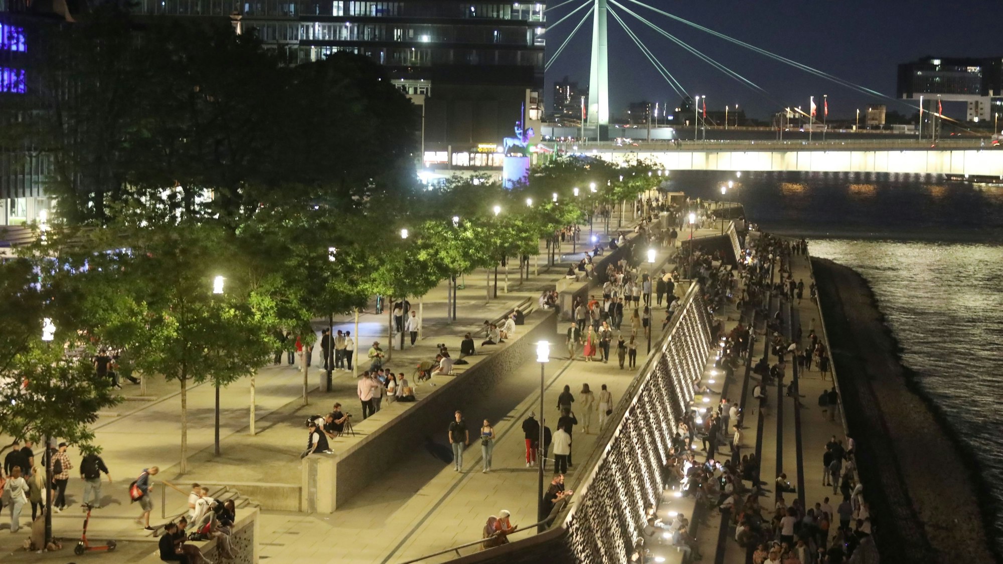 04.06.2022, Köln: Eine warme Nacht in Deutz.Menschen genießen auf den Treppen des Rheinboulevard den Frühsommer.