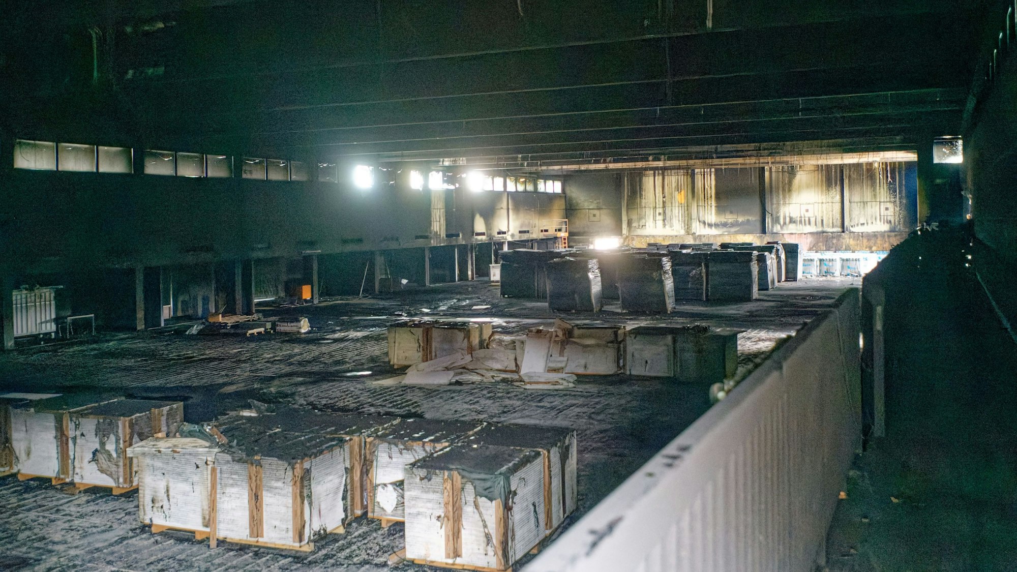 Die ausgebrannte Sporthalle der Gesamtschule Schlebusch ist jetzt Rußschwarz: Dämmmaterial liegt in der Halle. Foto: Ralf Krieger