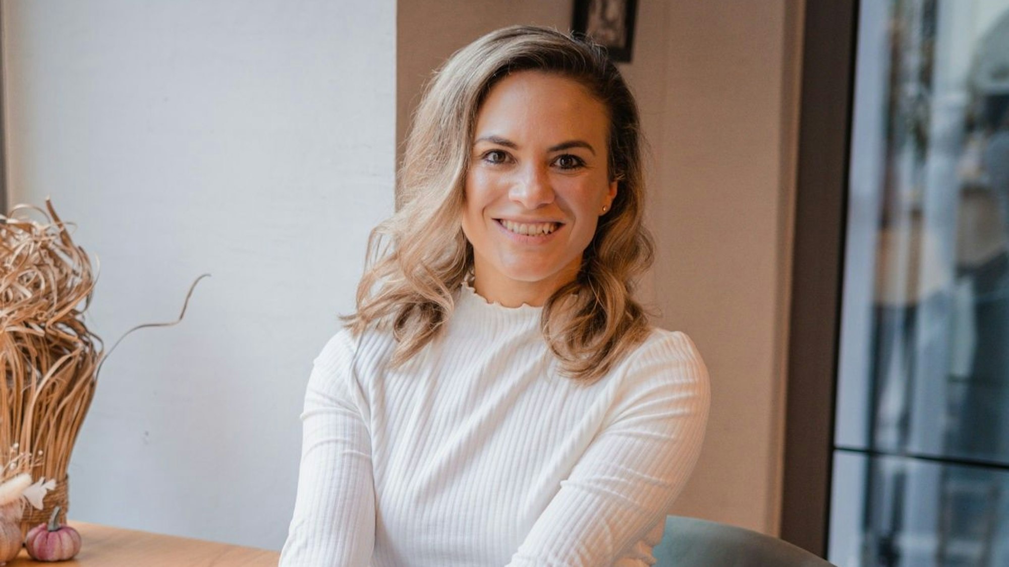 Sabrina Bah, Autorin von dem Vegan-Ratgeber „Vegane Ernährung – Einfach anfangen!“ sitzt auf einem Stuhl.