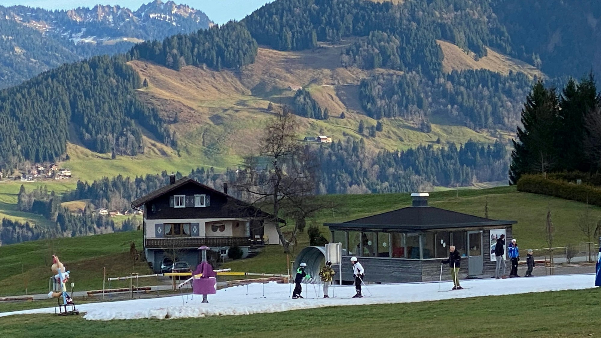 So machen die ersten Schritte auf Skiern eher keinen Spaß. Auf einem Flecken, der künstlich mit Schnee präpariert wurde, üben Anfänger.