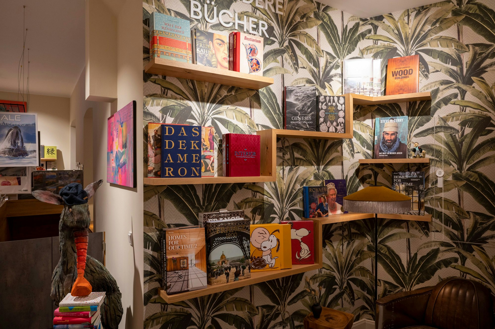 Alle Bücher werden frontal mit dem Cover in einer Leseecke mit Palmentapete präsentiert.