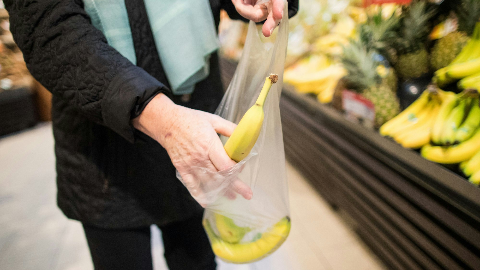 ARCHIV - 26.10.2017, Nordrhein-Westfalen, Kaarst: ILLUSTRATION - Eine Frau legt in einem Supermarkt eine lose Banane in eine Plastiktüte. (zu dpa «Bundesumweltministerin Svenja Schulze (SPD) stellt Fünf-Punkte-Plan für weniger Plastik und mehr Recycling vor» vom 26.11.2018) Foto: Marcel Kusch/dpa +++ dpa-Bildfunk +++