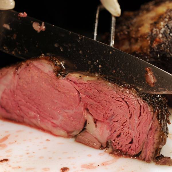 Das Foto zeigt ein Stück Rindfleisch, das aufgeschnitten wird.
