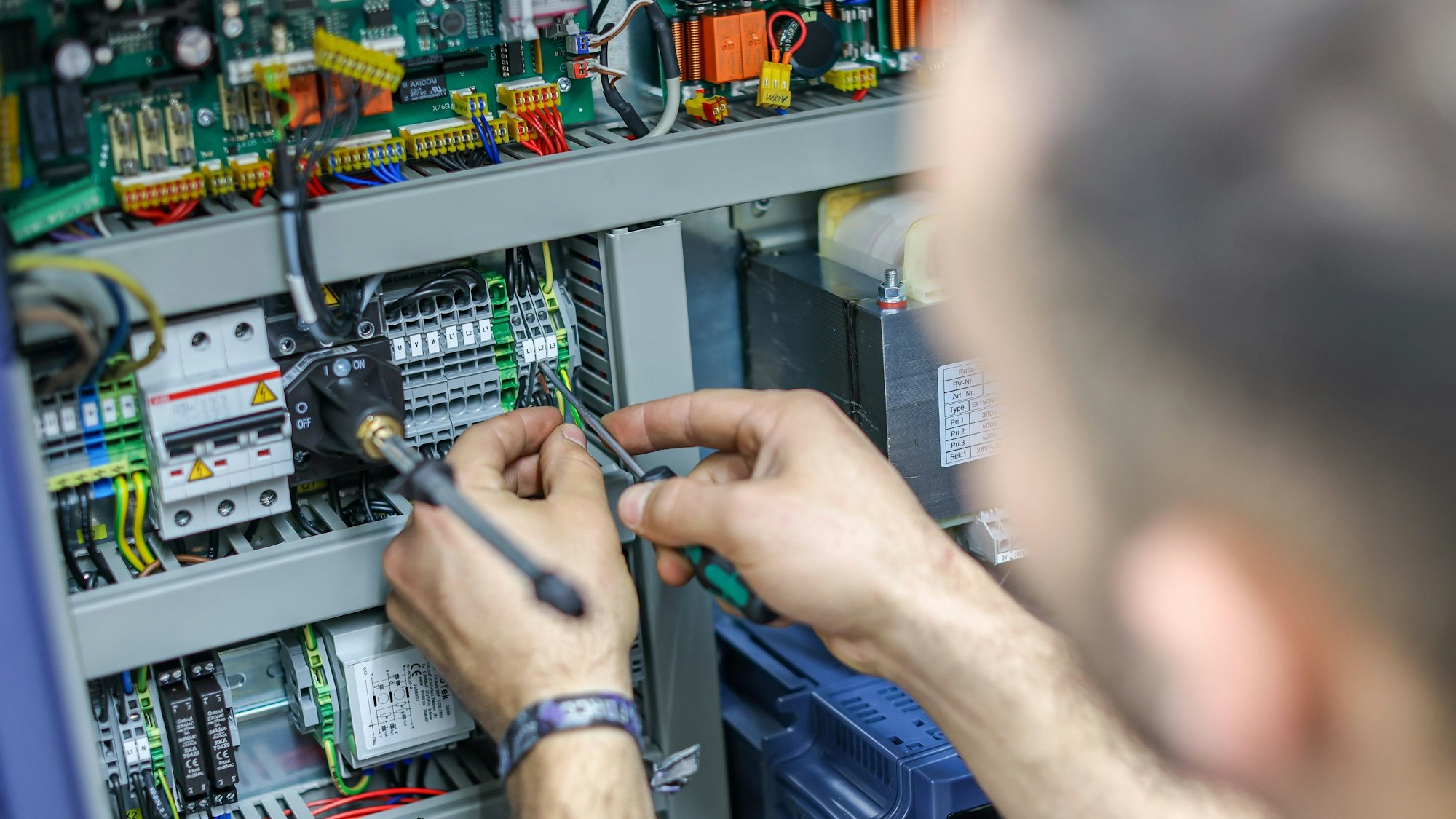 Ein Mitarbeiter der Terrot GmbH, hier im Dezember 2022 in Chemnitz, verdrahtet die Steuerung einer Großrundstrickmaschine. Dass Fachkräfte in Deutschland rar sind, ist lange bekannt. Auch die Agentur für Arbeit ermuntert Unternehmen, dem Mangel auf verschiedenen Arten zu begegnen.